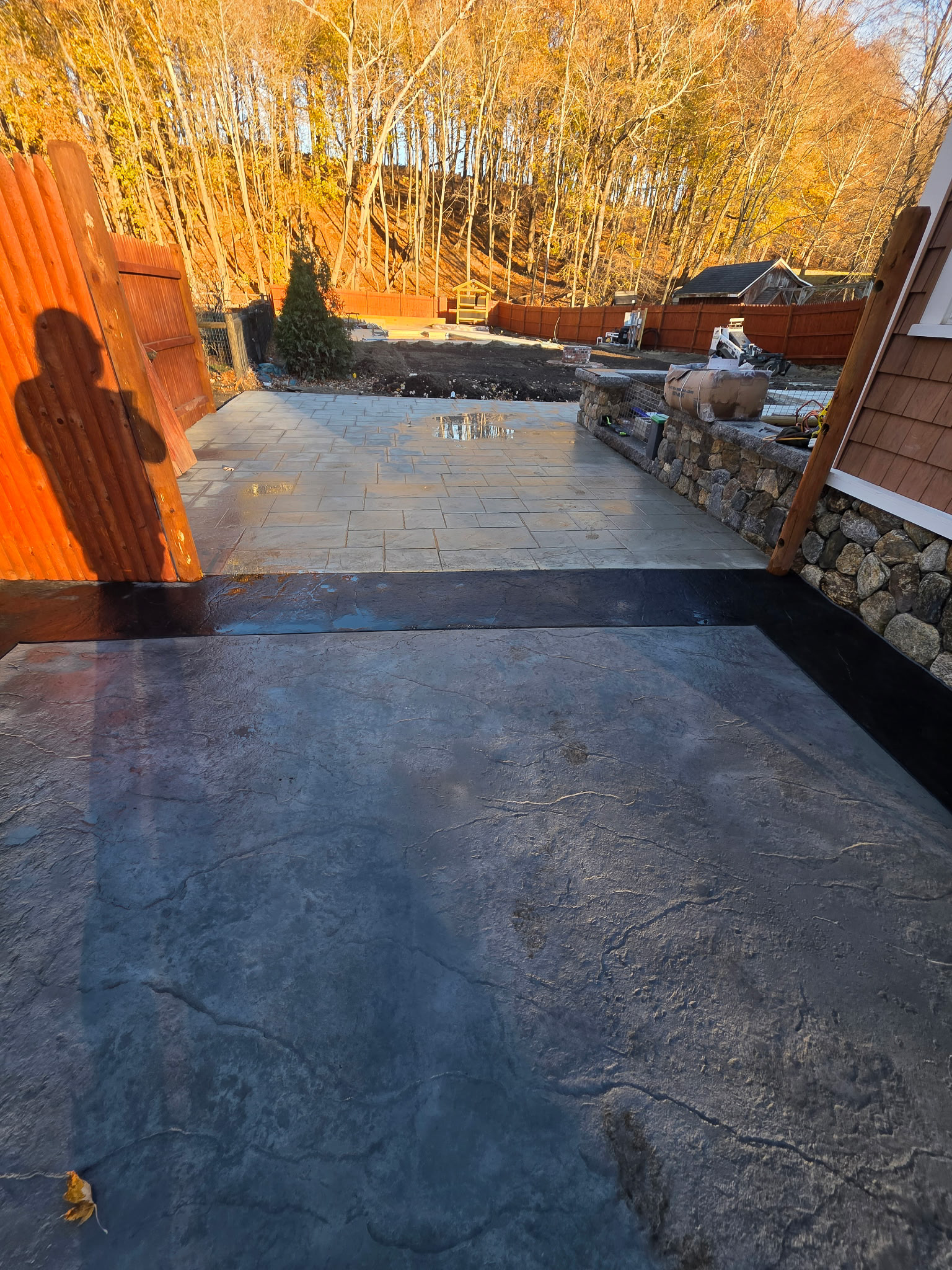 Exterior concrete patio with stone retaining wall by Patriot Concrete