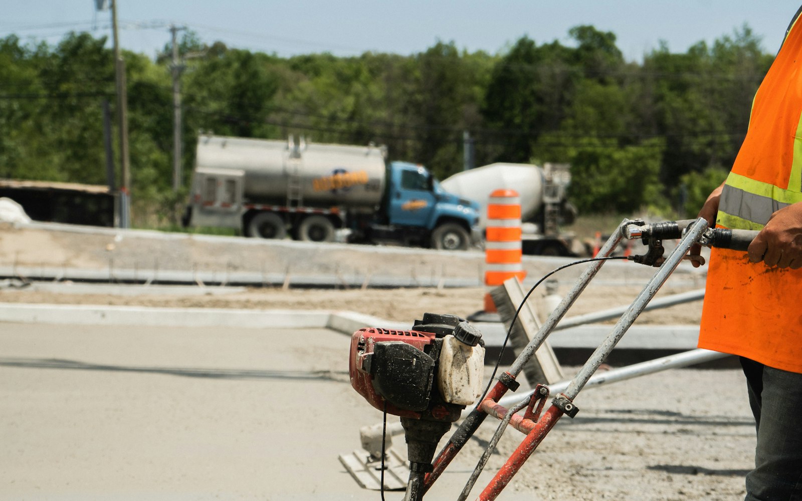 A professional concrete contractor power-screeding a freshly poured concrete slab on a job site near Rochester, NH