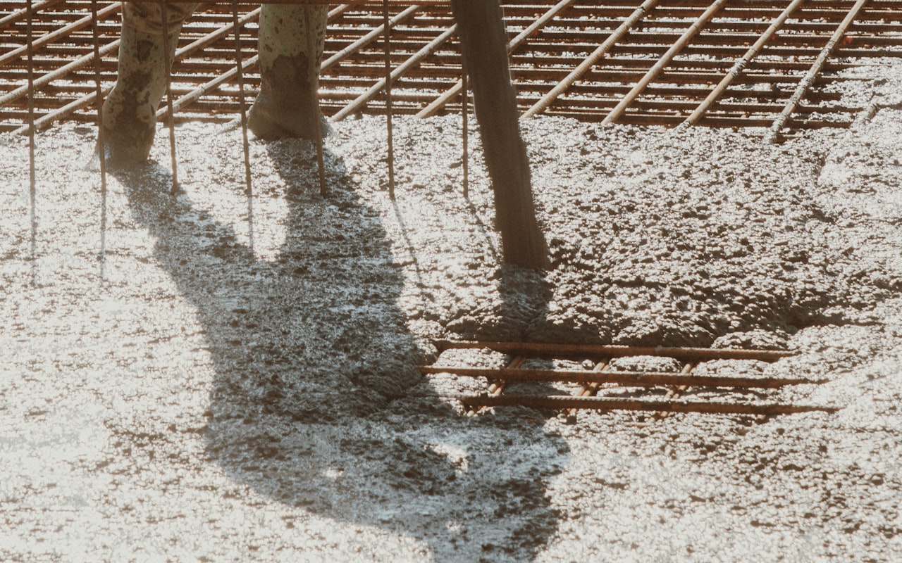 Wet concrete placed over a steel rebar grid during a driveway pour in New Hampshire — reinforcement is a key concrete driveway cost factor