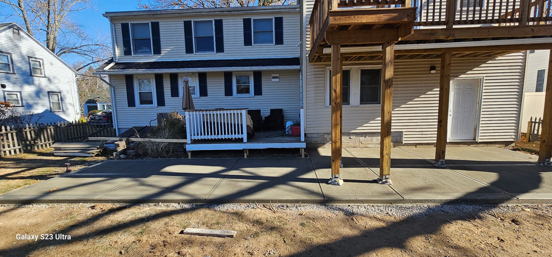 Newly poured residential concrete patio at the back of a New Hampshire home — concrete patio cost guide for Rochester, NH