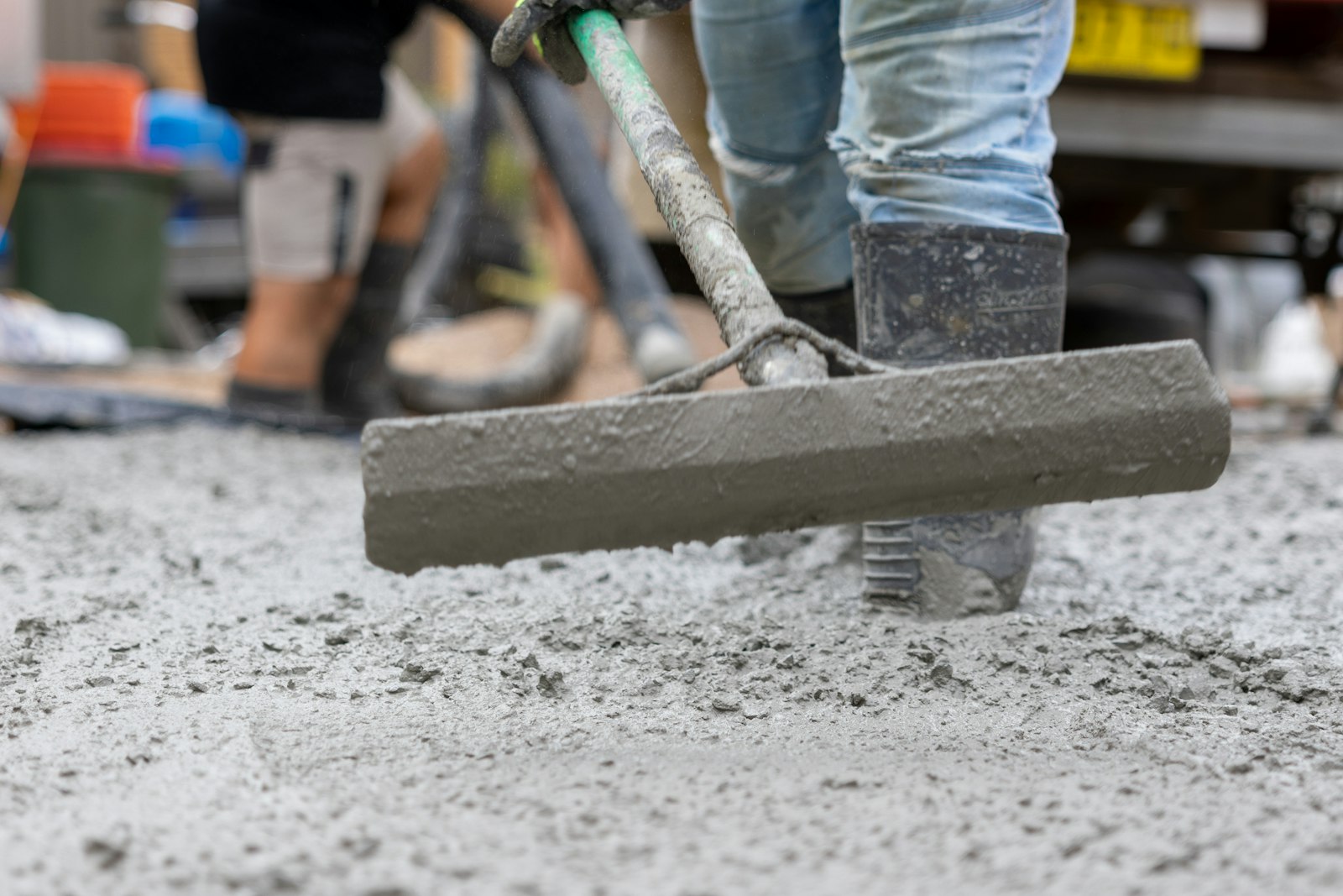 Bull float smoothing the surface of a freshly poured concrete slab during finishing