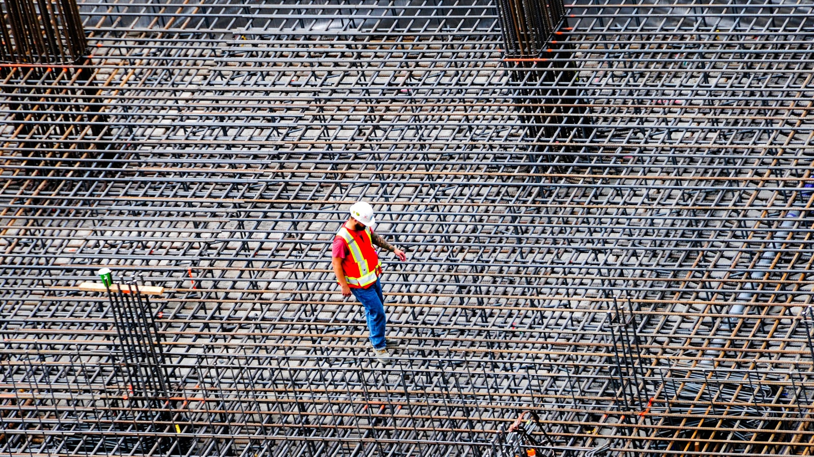 Steel rebar reinforcement grid laid out across a prepared base before a concrete slab pour