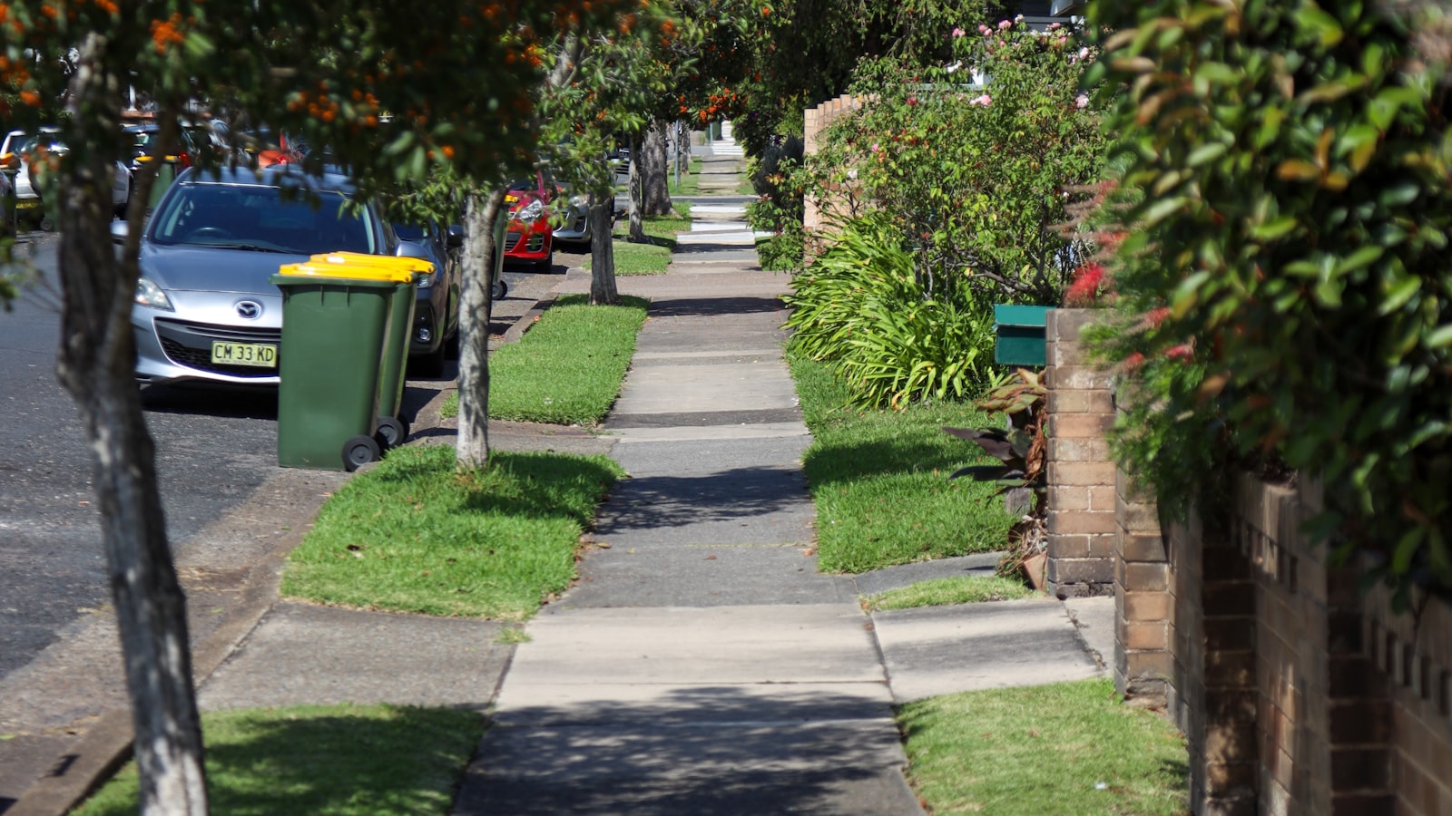 Concrete walkway and sidewalk running along the front yards of a residential New Hampshire neighborhood