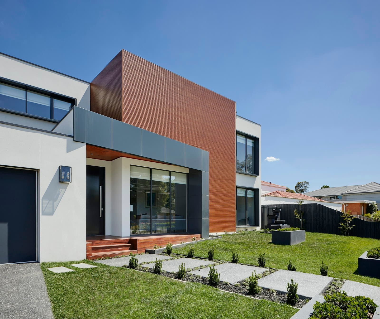 Concrete walkway with integrated plantings leading to the front entry of an NH area home