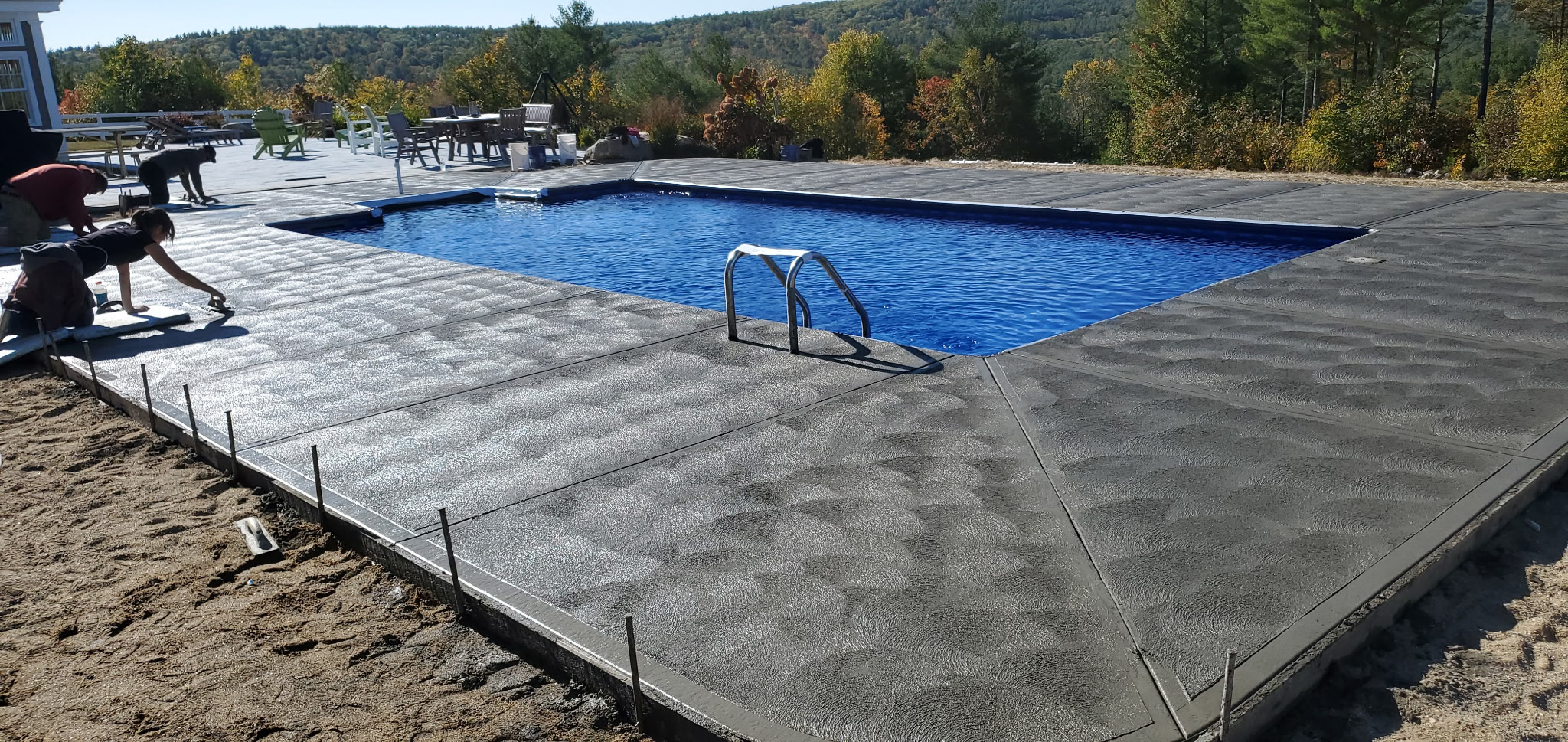 Concrete pool patio in a backyard setting