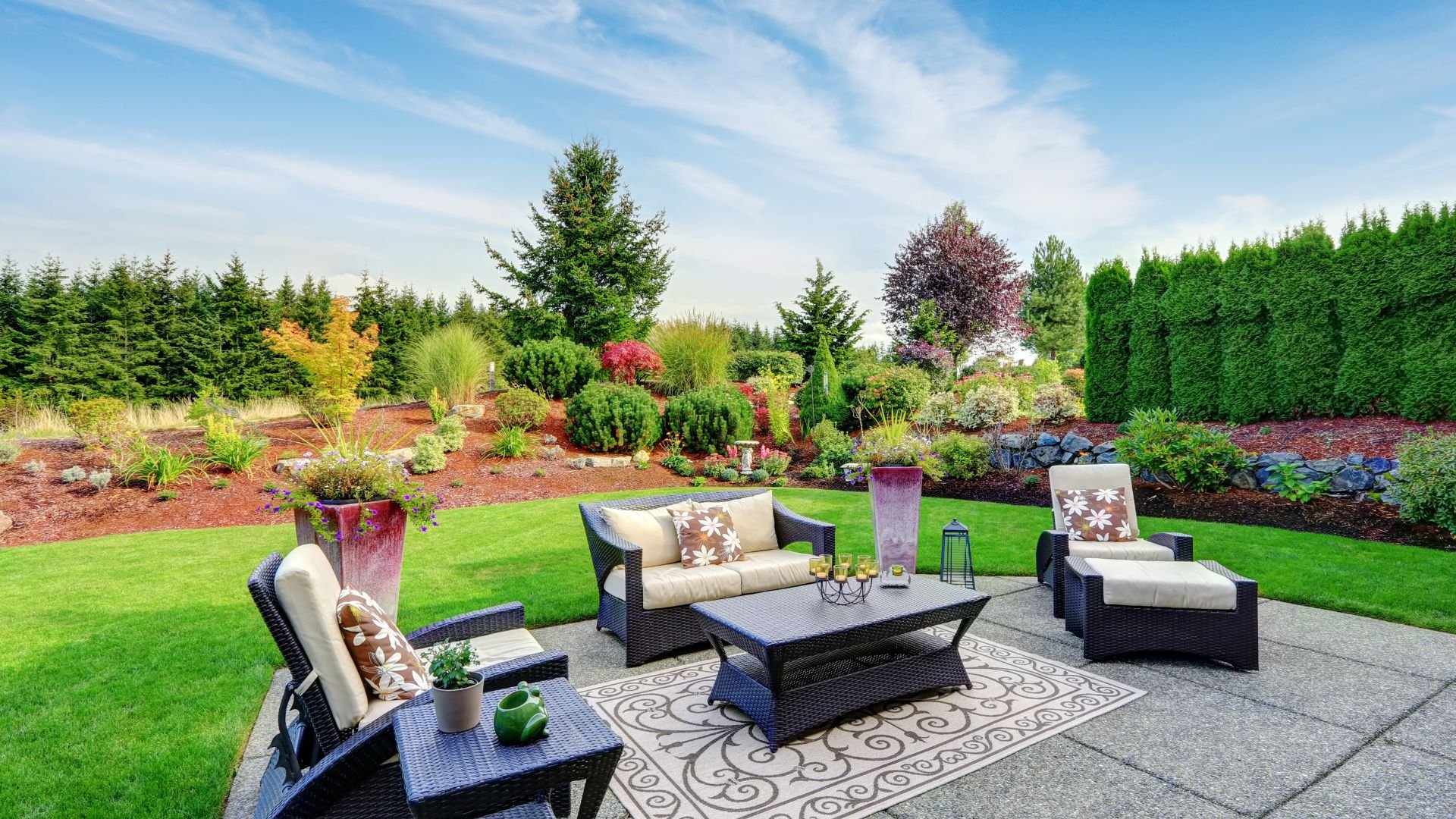 Luxurious backyard patio with outdoor furniture and beautifully landscaped garden