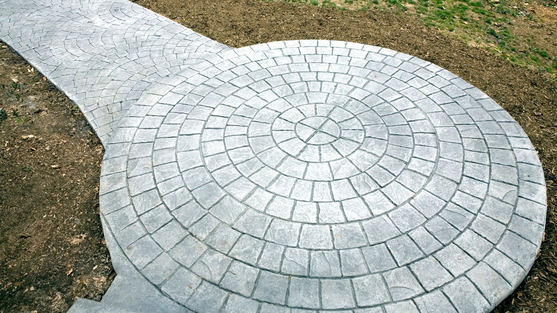 Circular stone patio with radial pattern made of gray stone pavers
