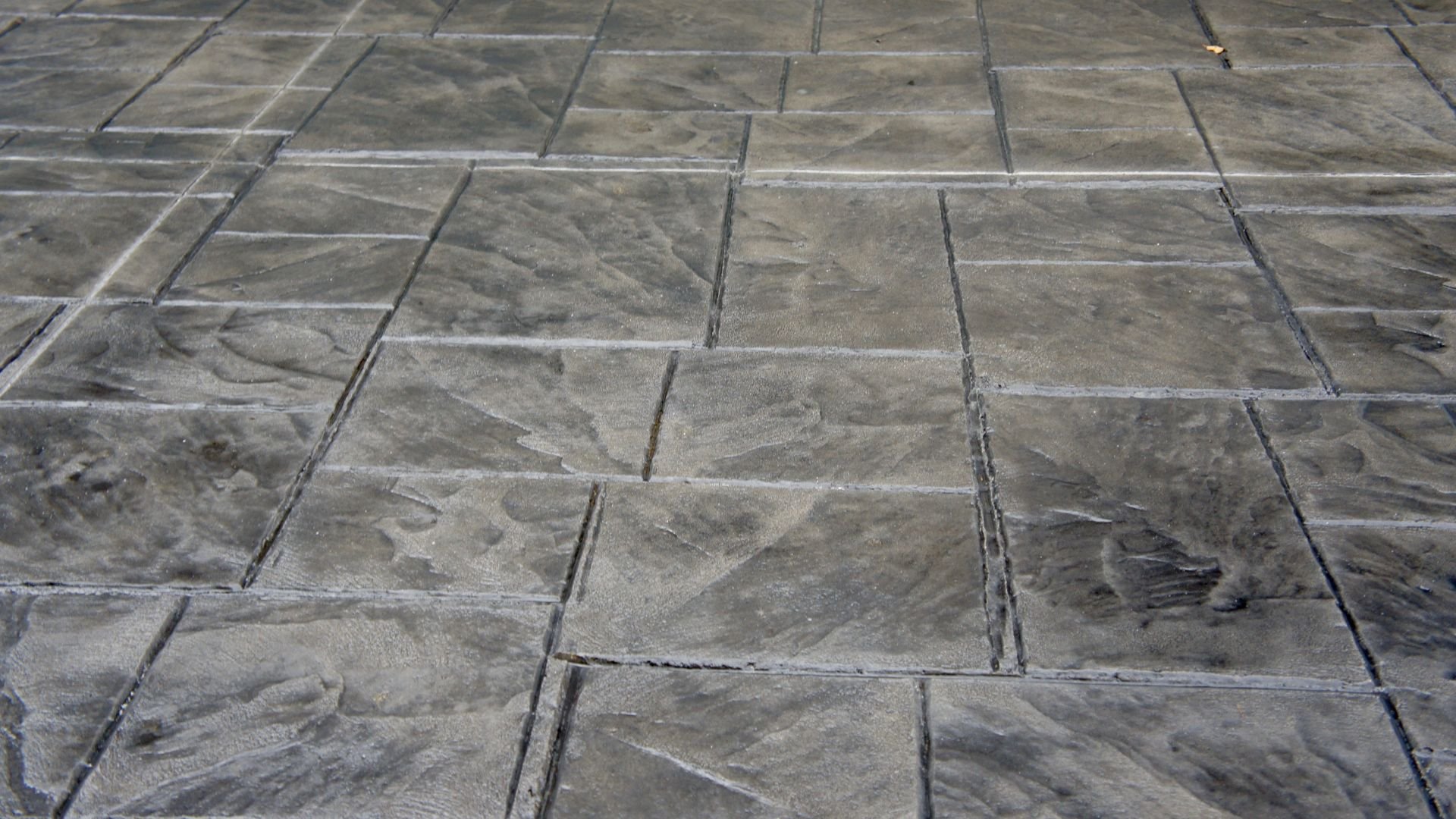 Textured gray concrete patio with stamped stone-like pattern