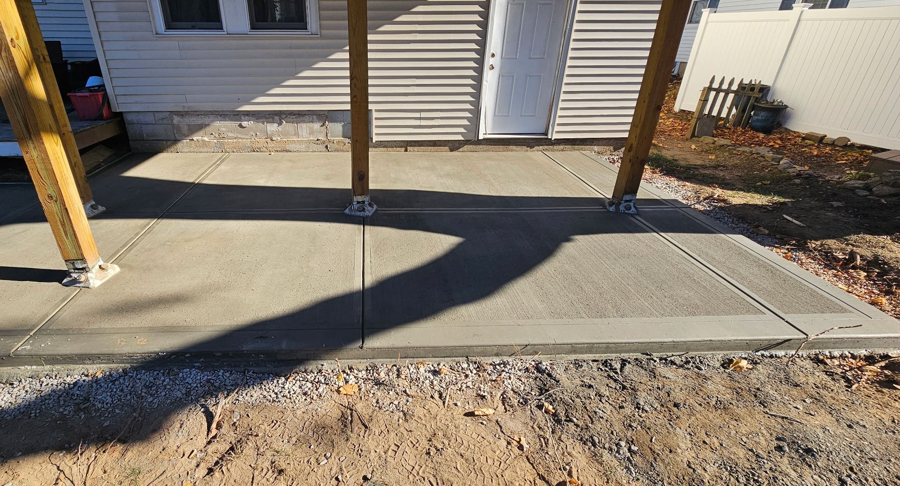 Fresh concrete patio pour under deck