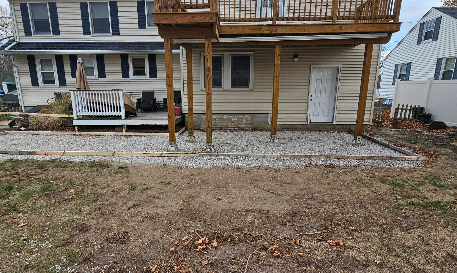 Patio gravel base preparation under raised deck